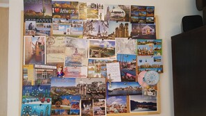 Un tablón de anuncios con temática de viajes, con diversas postales y notas sujetas, mostrando monumentos y ciudades de todo el mundo.