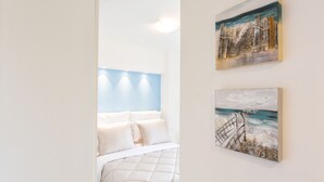 A bedroom with a bed, a blue accent wall, and two paintings. - Style House a few step from Sorrento main square (Sorrento)