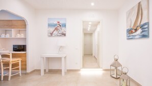 A modern room with a wooden desk, a white chair, a small table, and two paintings on the walls. - Style House a few step from Sorrento main square (Sorrento)