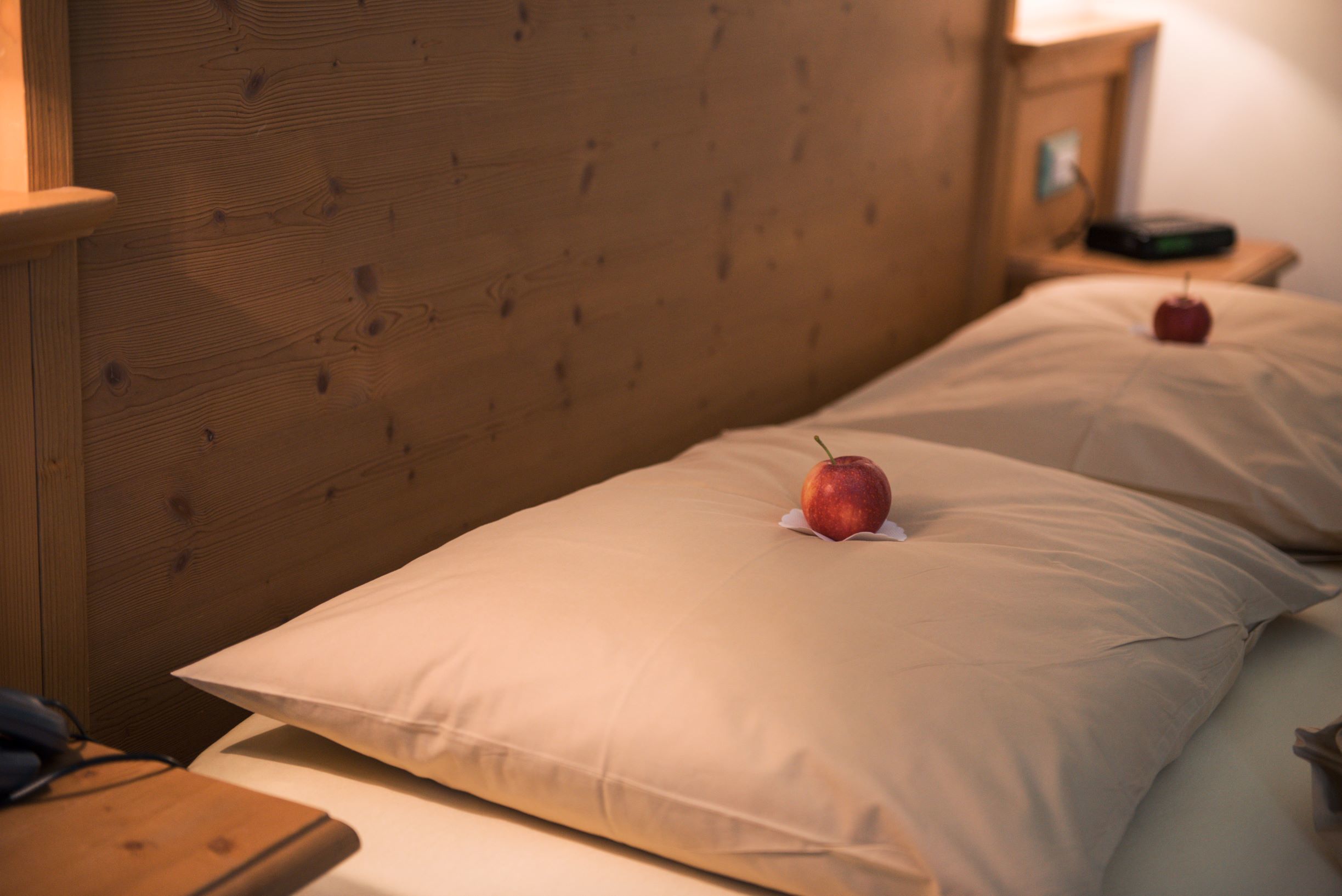 Ein hölzerner Kopfteil und ein Bett mit weißer Bettwäsche.