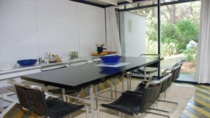 Una sala conferenze con un lungo tavolo, sei sedie e un'ampia finestra che si affaccia sul verde.