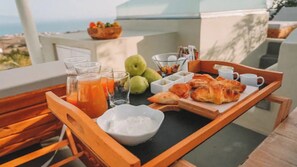 Enjoy a seaside breakfast on your balcony with a tray of fresh pastries, fruits, and juice.