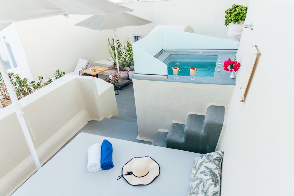 Terraza en la azotea con piscina, zona de estar y plantas en macetas.