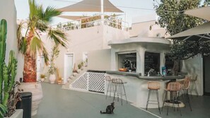 Relax in a serene outdoor space with a seating area, bar, and lush greenery.