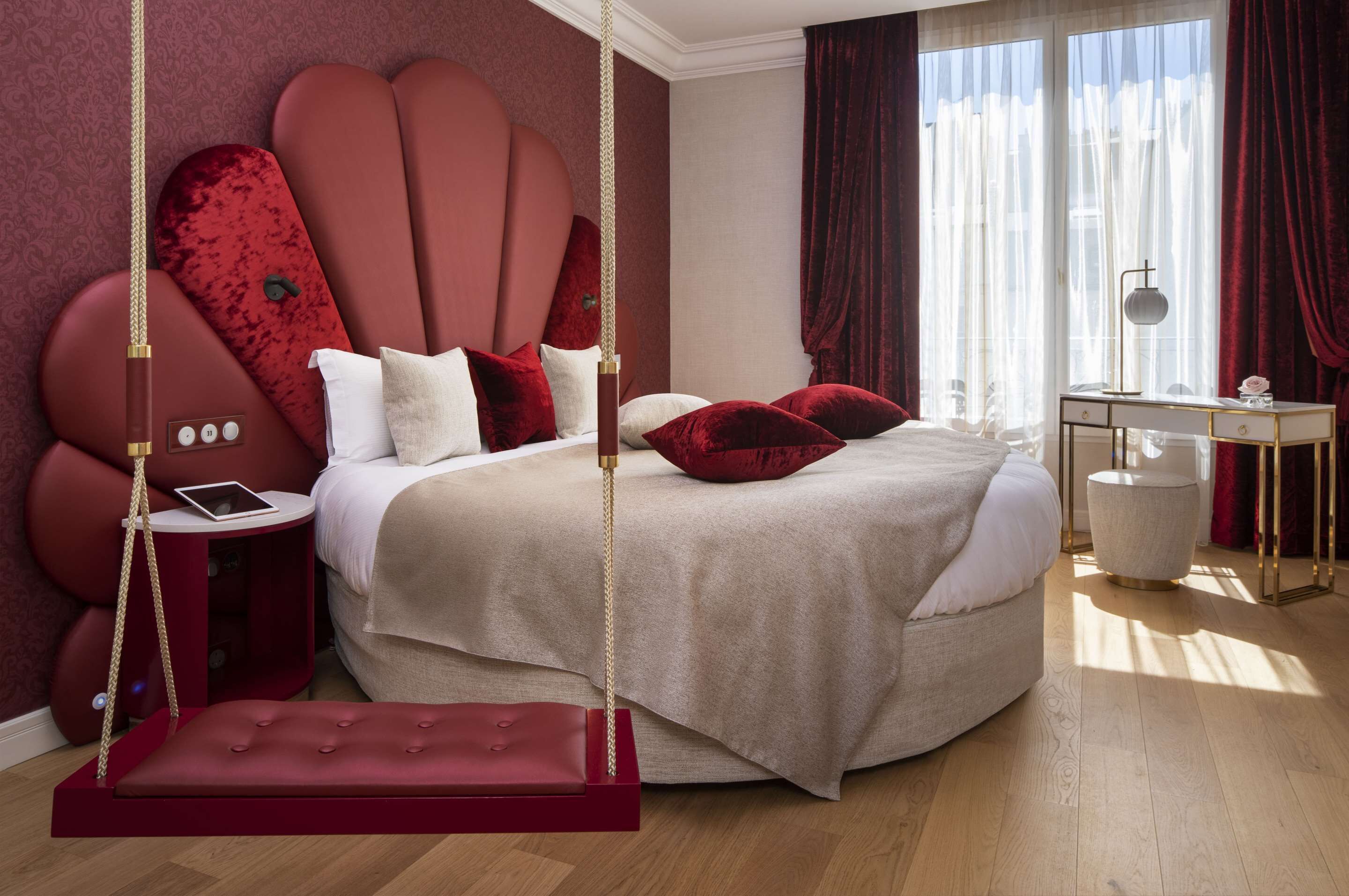 Ein Schlafzimmer mit einem großen Bett, einem Schaukelstuhl, einem Nachttisch und einem Schreibtisch mit Lampe.