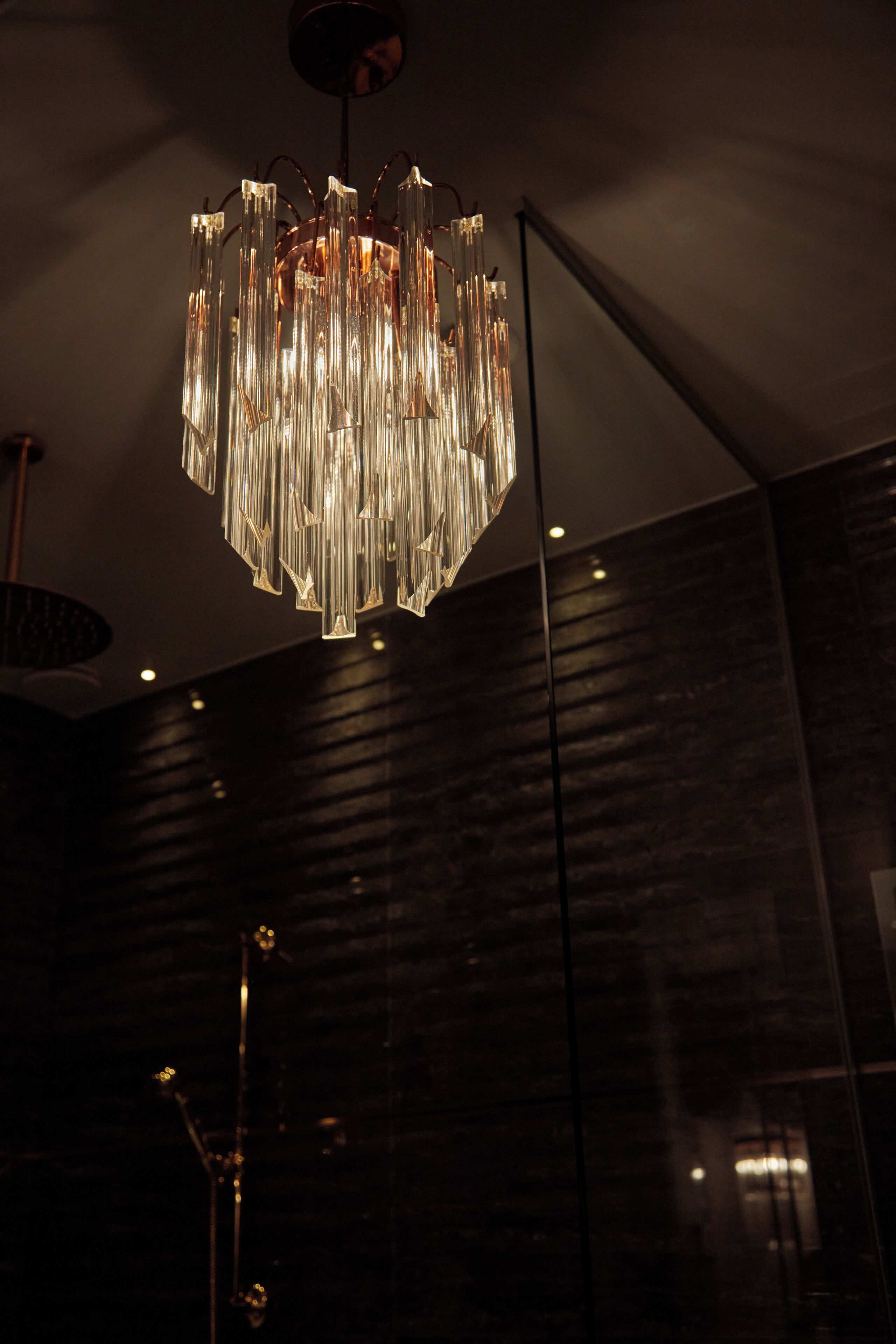 A modern chandelier with multiple crystal elements hanging from the ceiling.