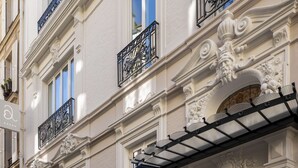 A building facade with ornate architectural details, including decorative balconies and a wrought iron awning. - Paris j'Adore Hotel & Spa (Paris)