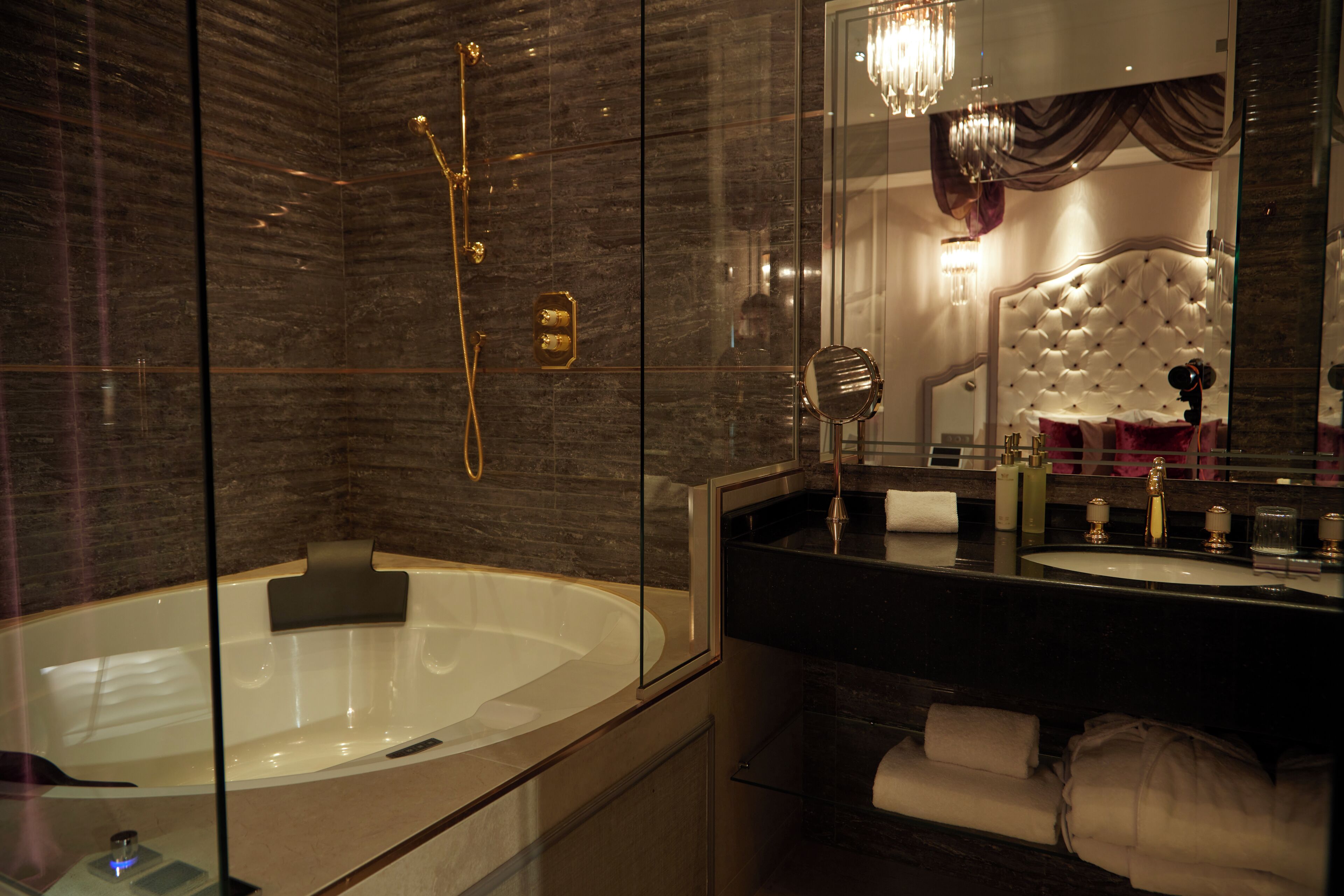A modern bathroom with a large bathtub, a separate shower area, and a vanity with a mirror.