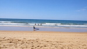 A beach with clear skies, calm waves, and footprints in the sand. - T2 Porto Marina, a 4 min. Marina Vilamoura (Quarteira)