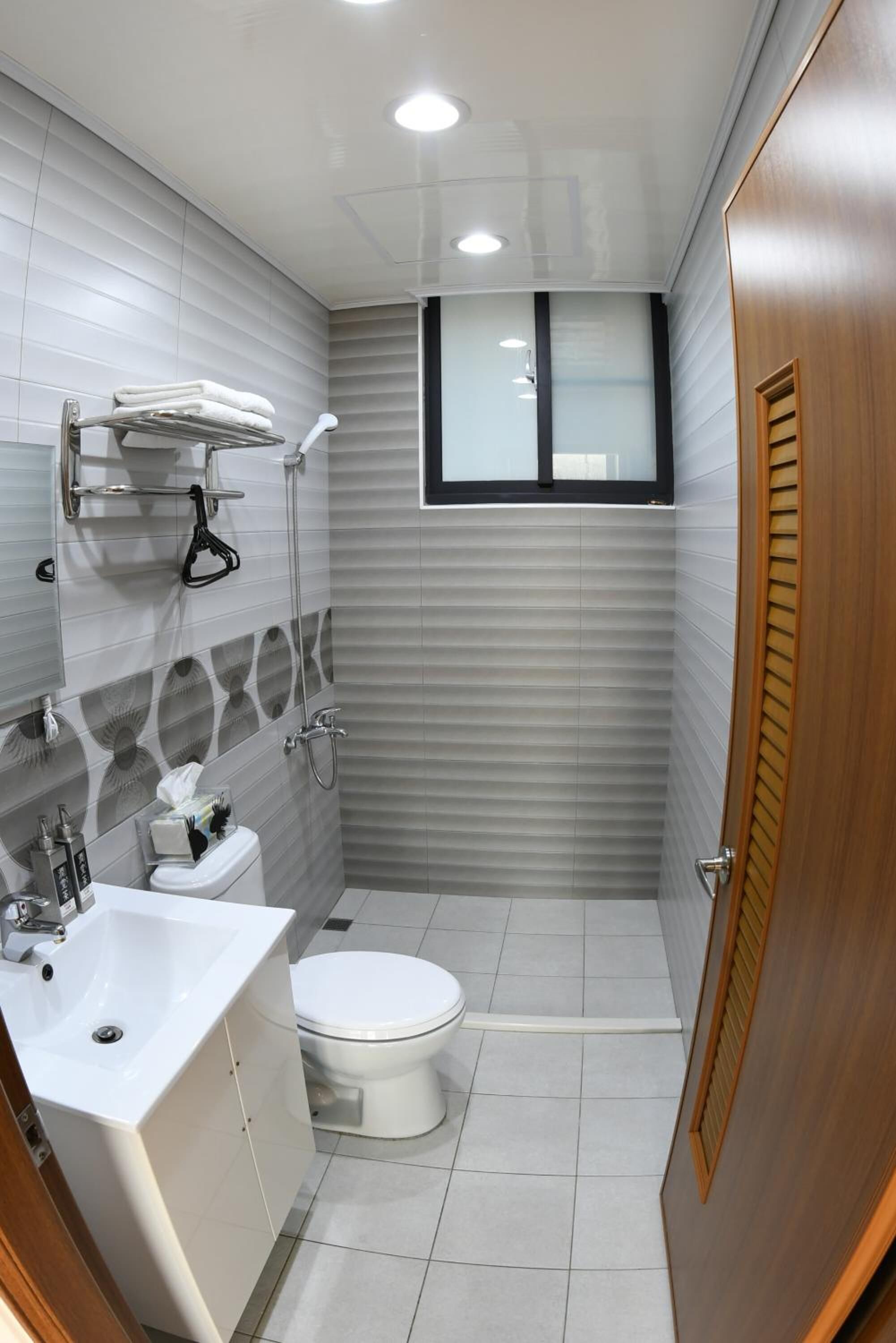 Un baño pequeño con inodoro, lavamanos y ducha.