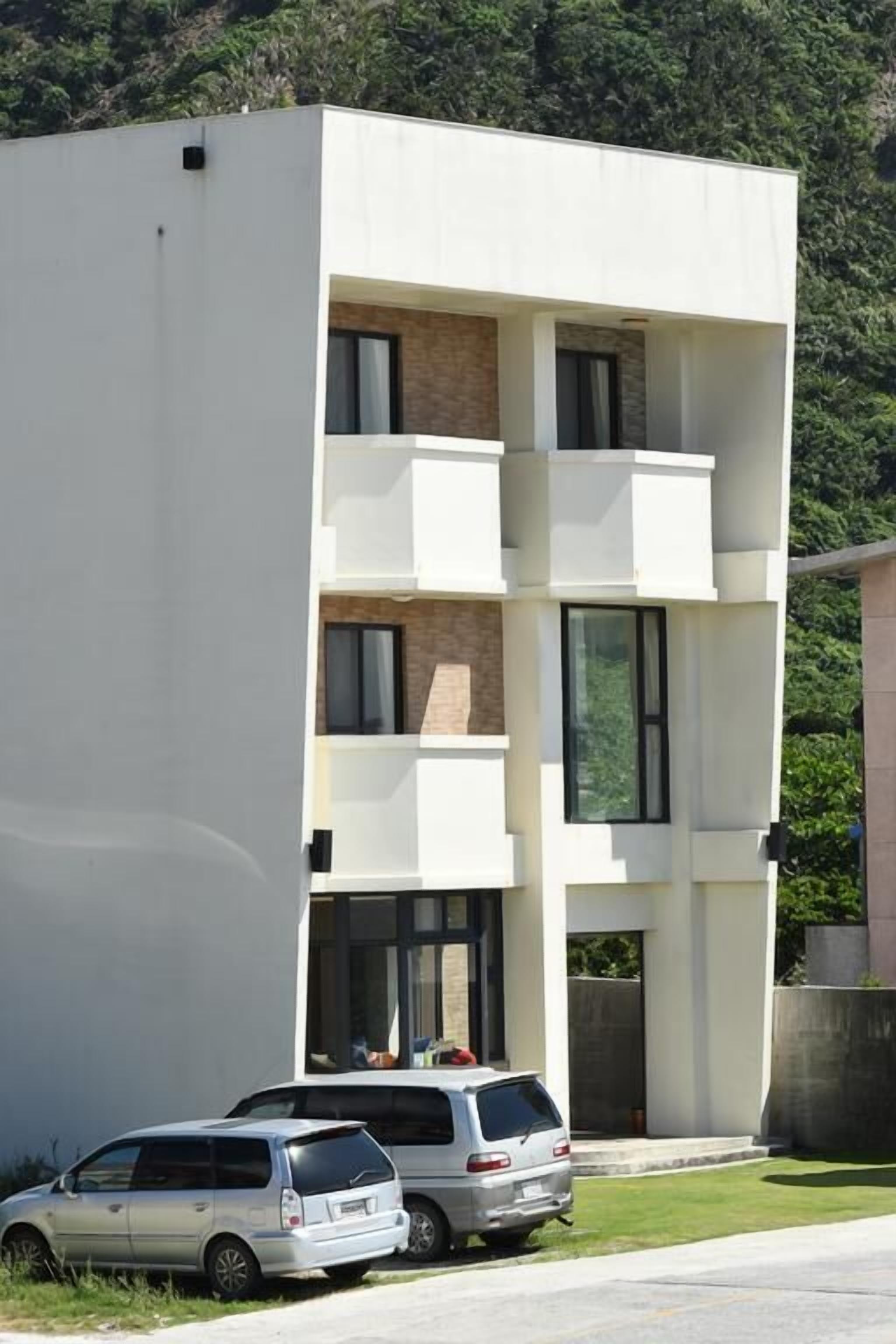 Un bâtiment moderne à deux étages, doté d’un toit plat, de grandes fenêtres et d’un balcon à l’étage supérieur.