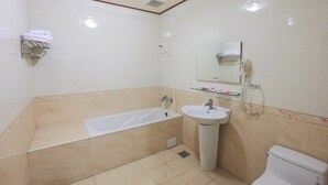 A bathroom with a bathtub, sink, and toilet.