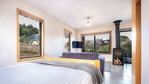 Ein Schlafzimmer mit einem großen Bett, einer Couch, einem Fernseher und einem Kamin.