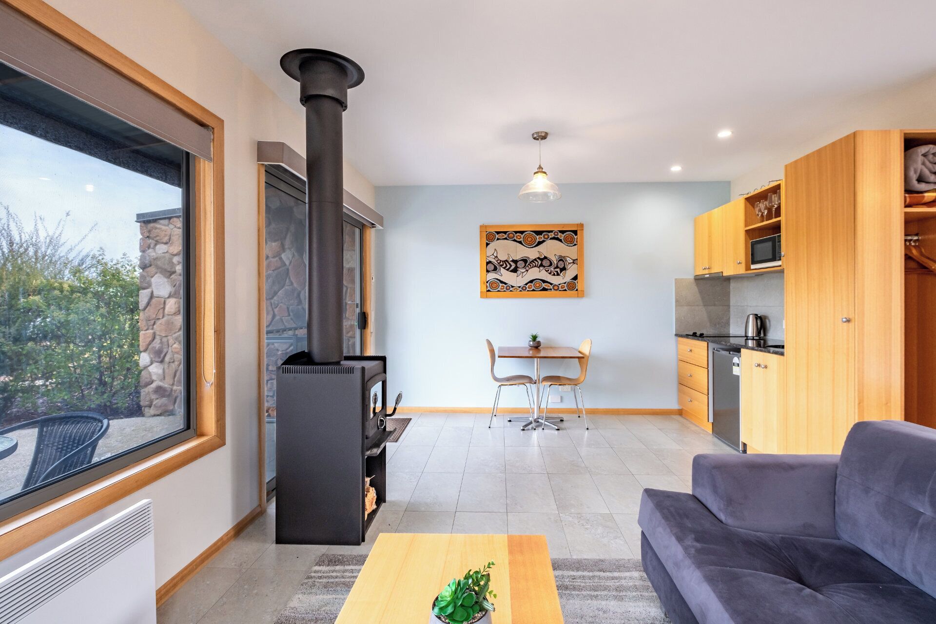 Een moderne woonkamer met een open haard, een eethoek en een keuken.