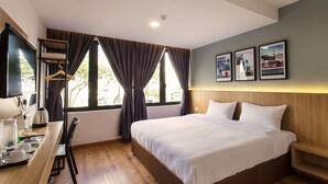 A hotel room with a bed, bedside table, chair, desk, and a window with curtains. - Hotel Insuna (Johor Bahru)