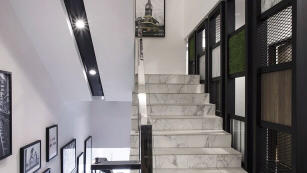 A modern staircase with white marble steps and black railings, leading to an upper floor. - Hotel Insuna (Johor Bahru)