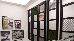 A modern interior with a staircase, glass railings, and framed pictures on the walls. - Hotel Insuna (Johor Bahru)