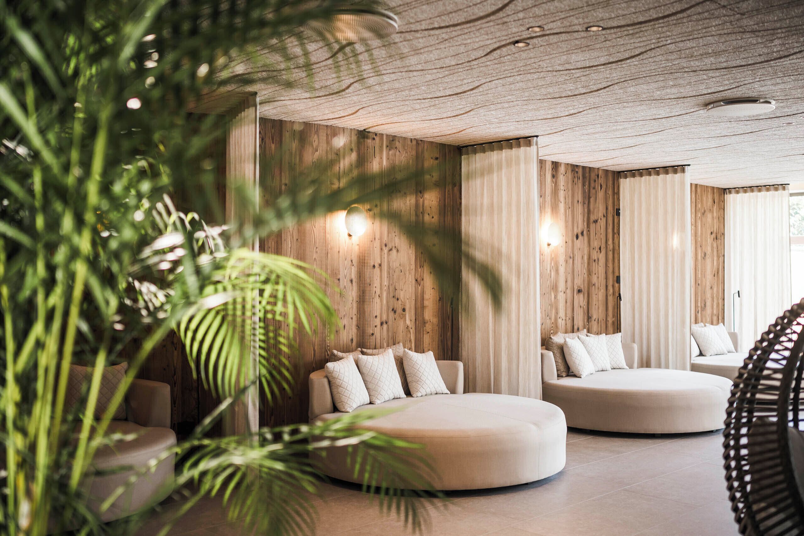 Een modern interieur met een ronde zithoek, houten wanden en een plafond met een bijzondere textuur.
