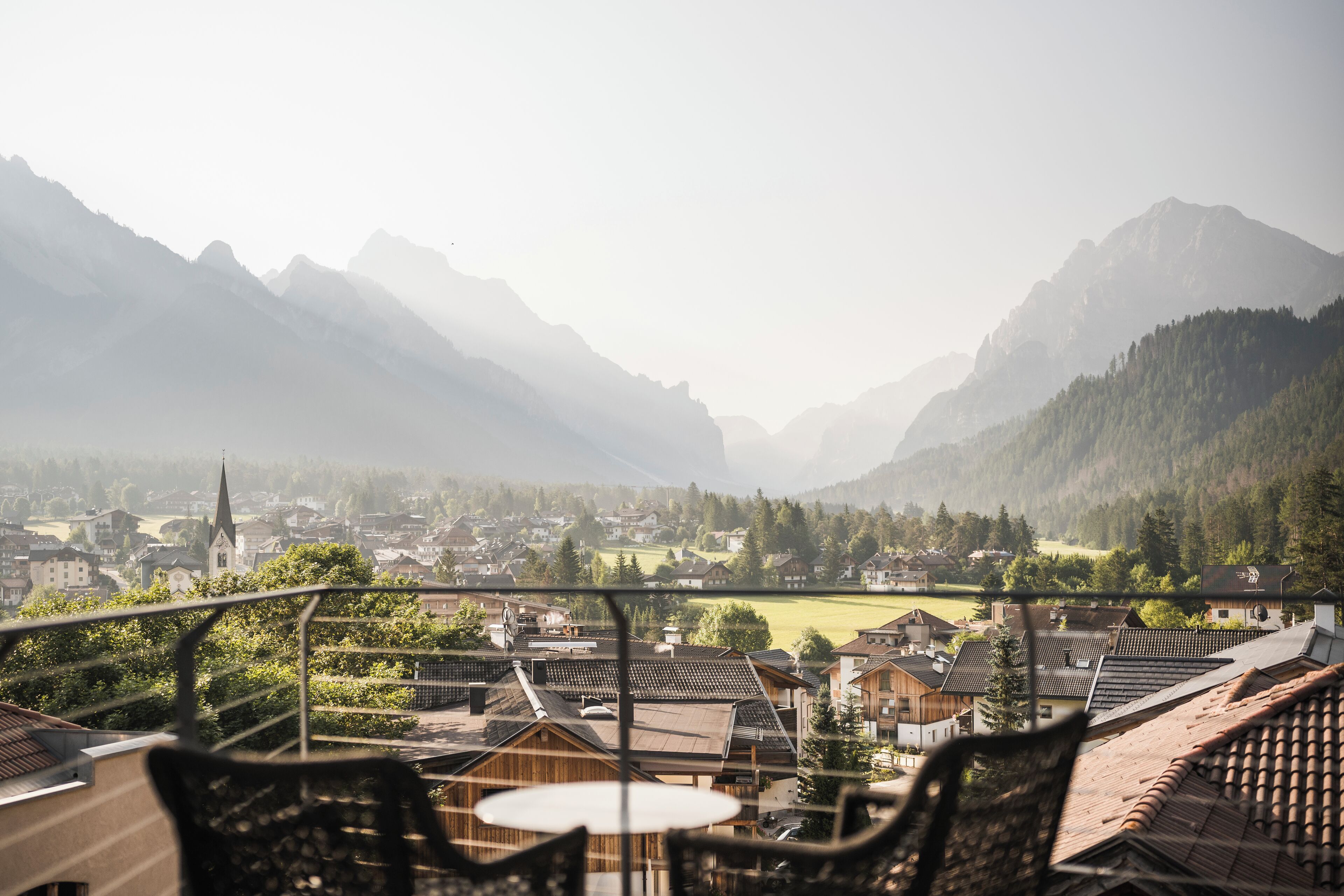A balcony with a view of a town and mountains.