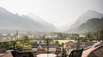 Un balcon avec vue sur la ville et les montagnes.