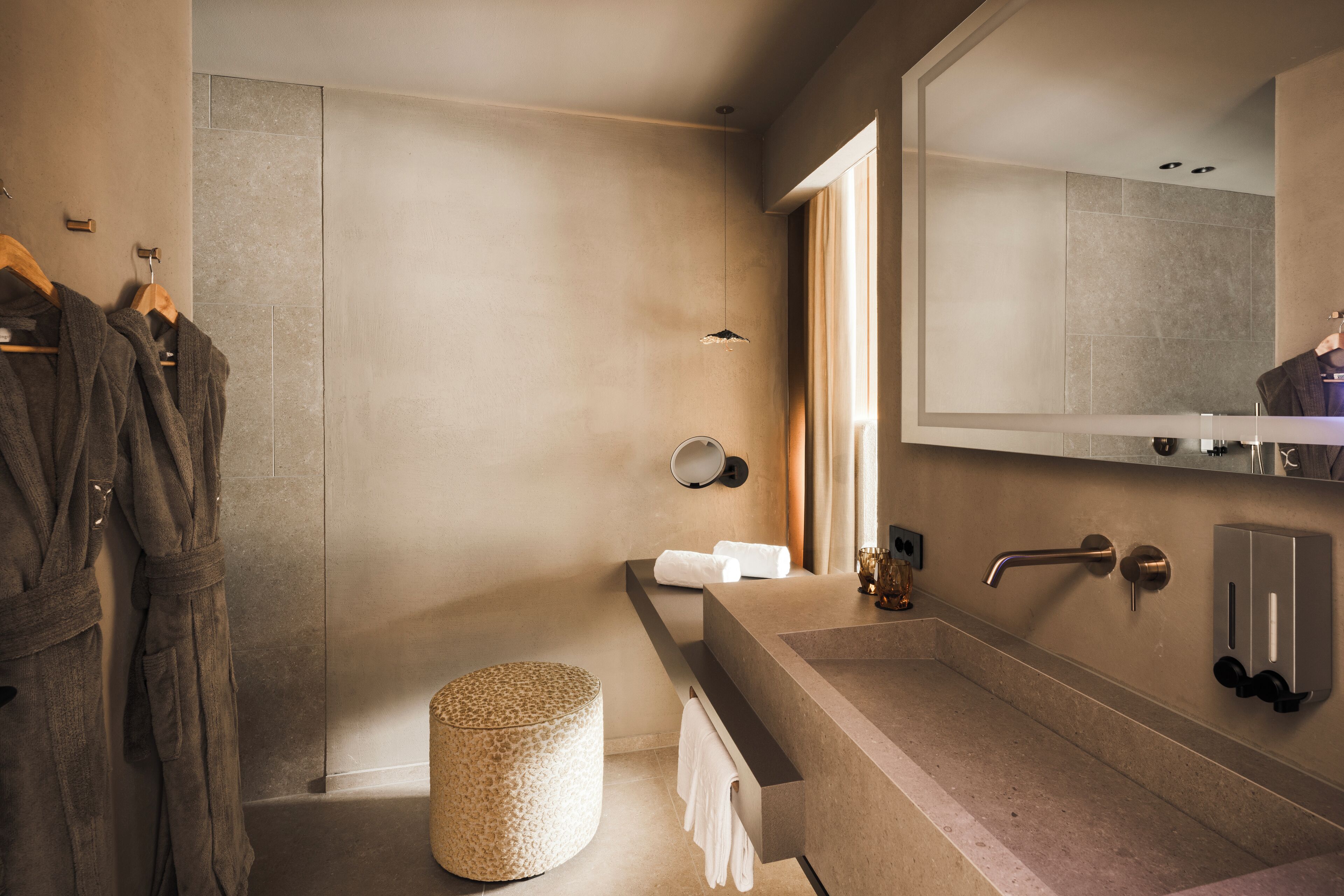 Ein modernes Badezimmer mit einem großen Spiegel, einer Badewanne, einem Waschbecken und einem Handtuchhalter.