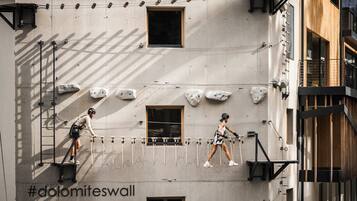 Un edificio con una pared de escalada, una escalera y un hashtag en la pared.