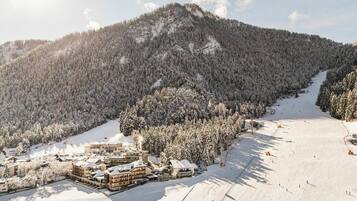 A snow-covered mountain with a ski resort, including buildings and a ski lift.