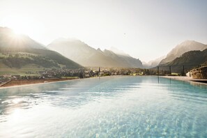 Une piscine avec vue sur les montagnes et la ville.