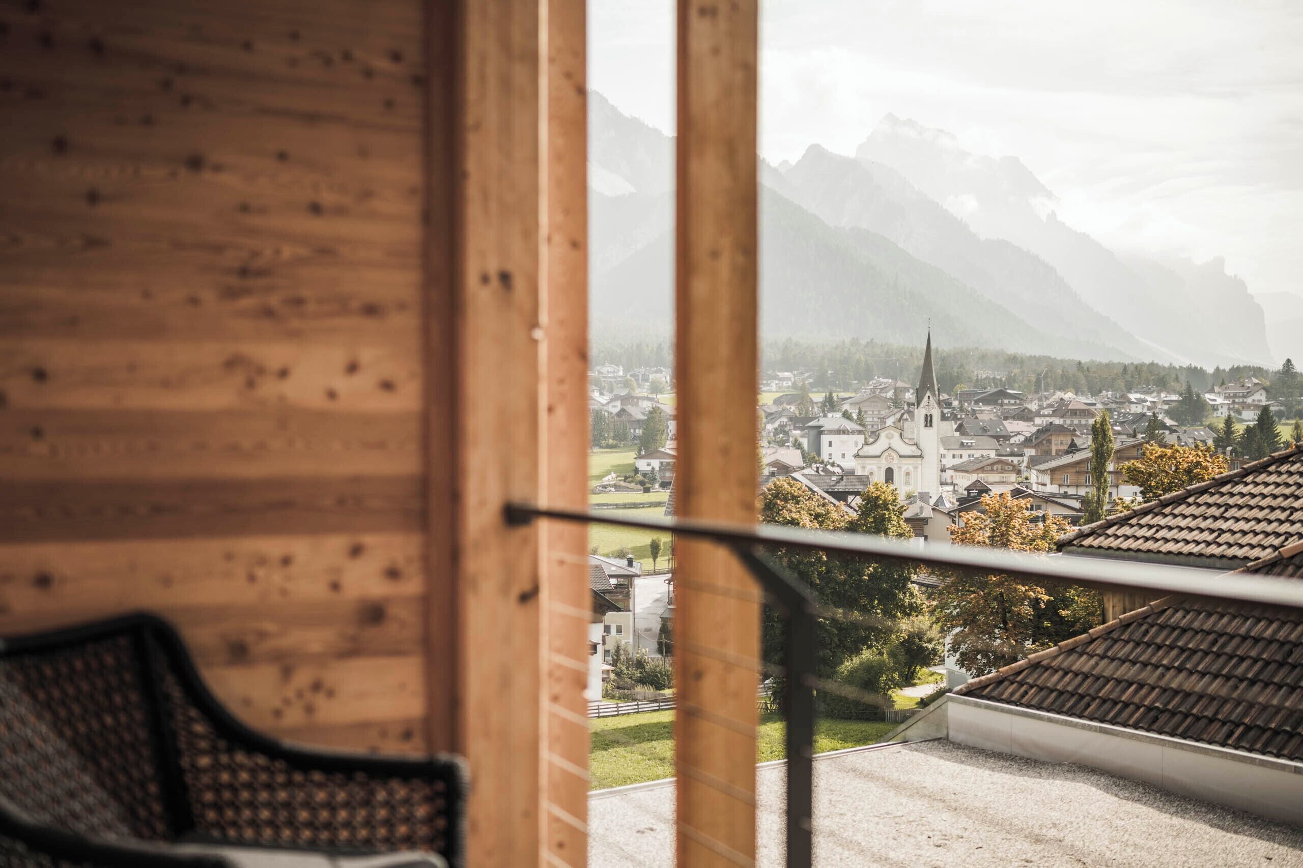 Holzvertäfelung mit Blick auf eine Stadt und Berge.