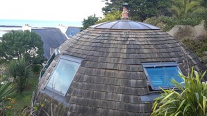 A house with a sloped roof, two skylights, and a chimney. - Original round wood house T3 sea view (Locquirec)