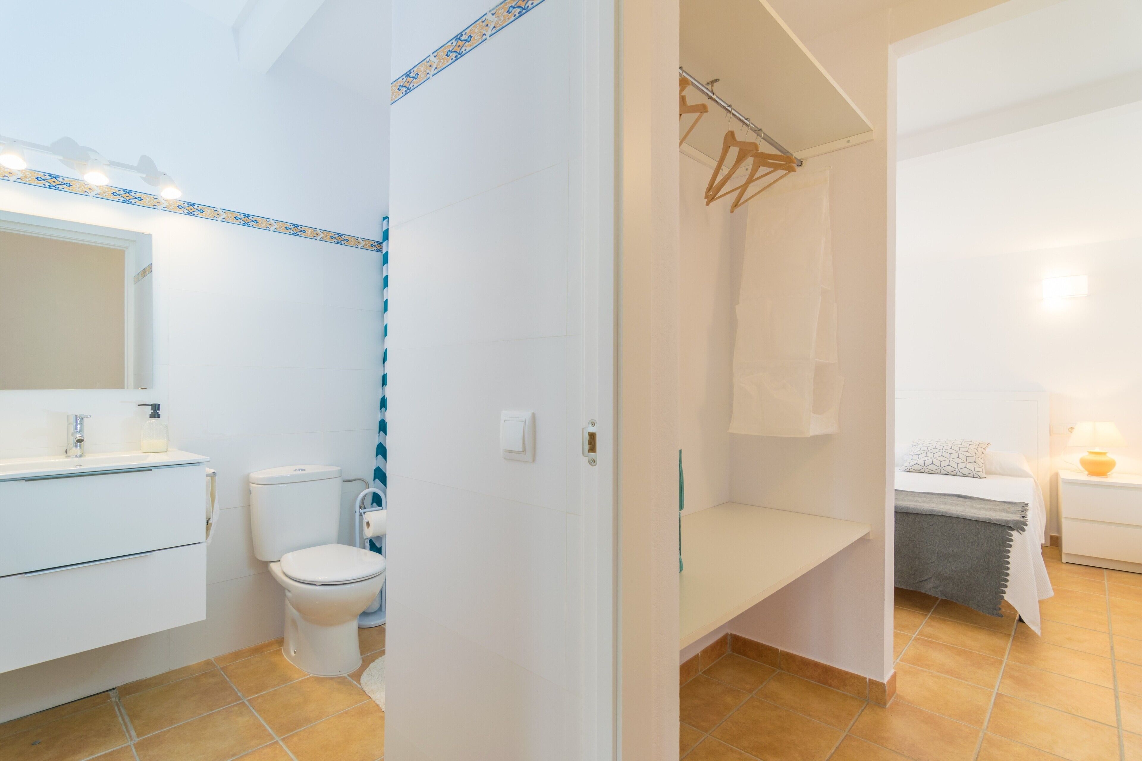A bathroom with a toilet, sink, and shower area.