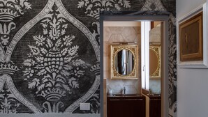 A hallway with a detailed black and white wall mural, a mirror with an ornate frame, and a dark wooden door. - San Marco Luxury property with terraces. Muneghe (Venezia)