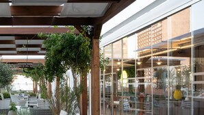 An outdoor seating area with wicker furniture and potted plants.
