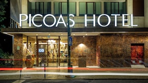 The exterior of PICOAS HOTEL with a clear entrance, a large potted plant, and a visible entrance number.