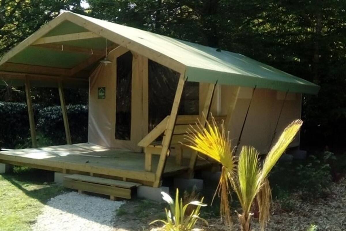 Une petite construction en bois, dotée d’un toit en pente, d’un porche abrité et d’une petite fenêtre.
