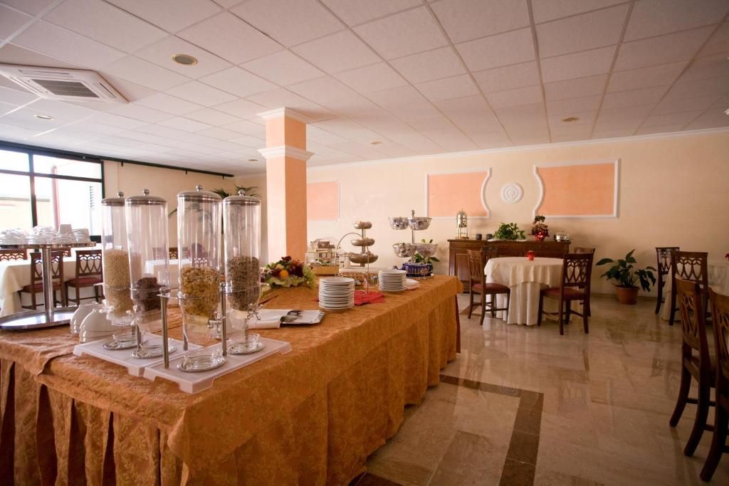 Un buffet con distributori trasparenti per salse e condimenti, una varietà di piatti e un tavolo con tovaglia bianca.