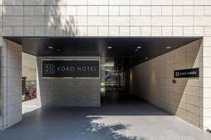 Una entrada de hotel moderna con un letrero que dice 'KOKO HOTEL'.
