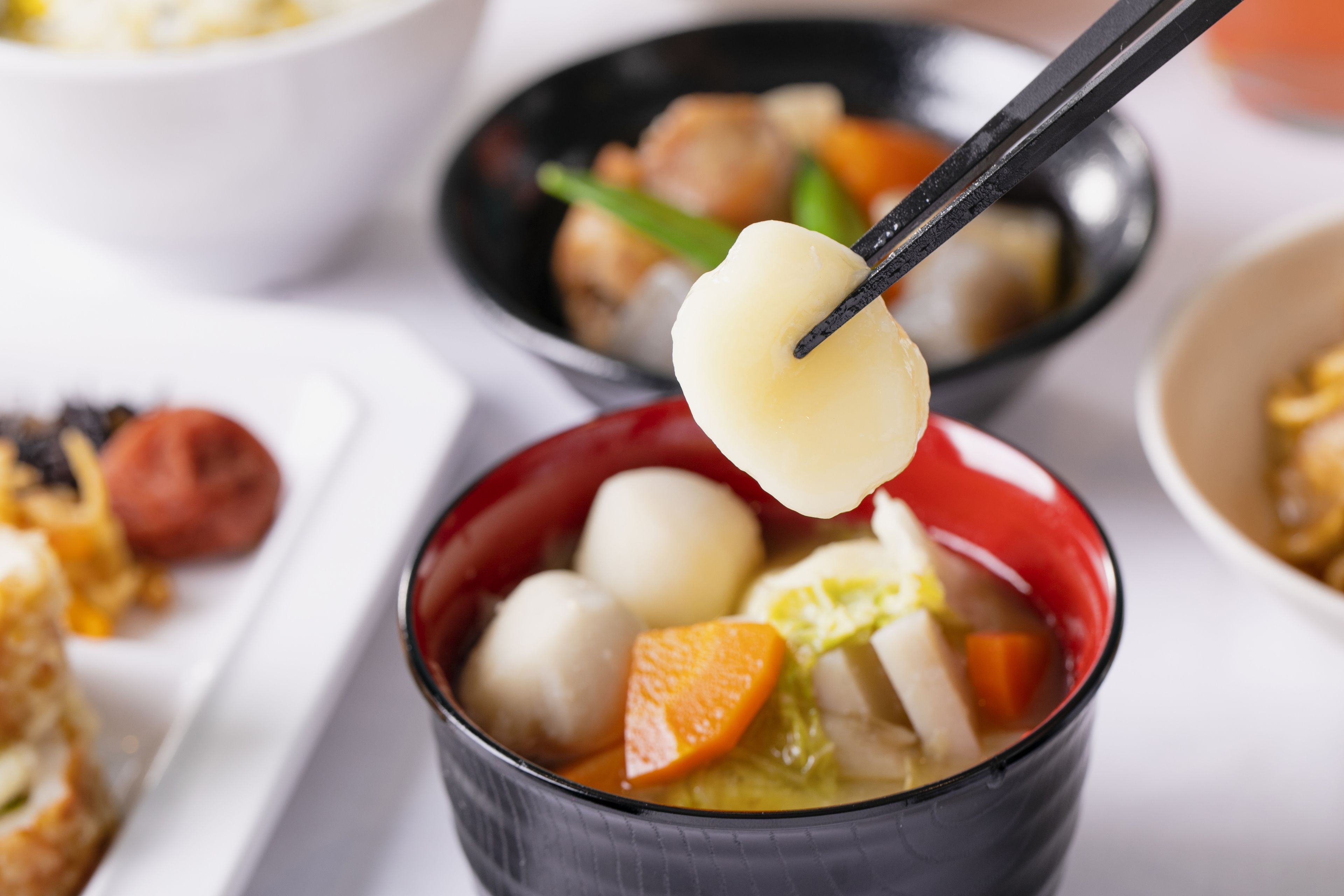 Uma tigela de sopa com diversos ingredientes, incluindo vegetais e dumplings.