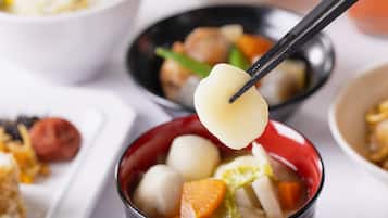 Uma tigela de sopa com diversos ingredientes, incluindo vegetais e dumplings.