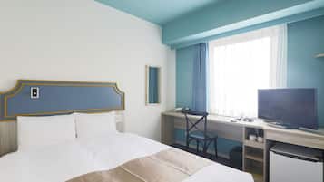 A hotel room with a bed, desk, television, and a window with curtains.