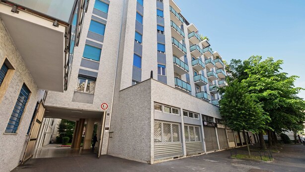 Un immeuble à plusieurs étages doté d’une architecture moderne, avec des balcons et de grandes fenêtres.