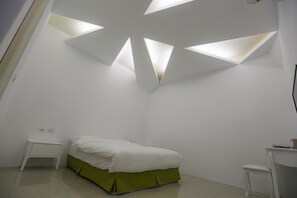 A bedroom with a bed, a nightstand, a desk, and a chair. - Return Home B&B (Yuli)