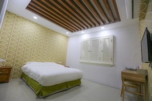 A bedroom with a bed, a desk, a chair, and a window with shutters. - Return Home B&B (Yuli)