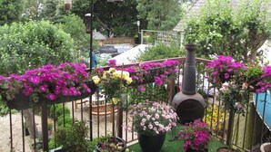 Un jardin agrémenté de plantes en pot et d’un barbecue.
