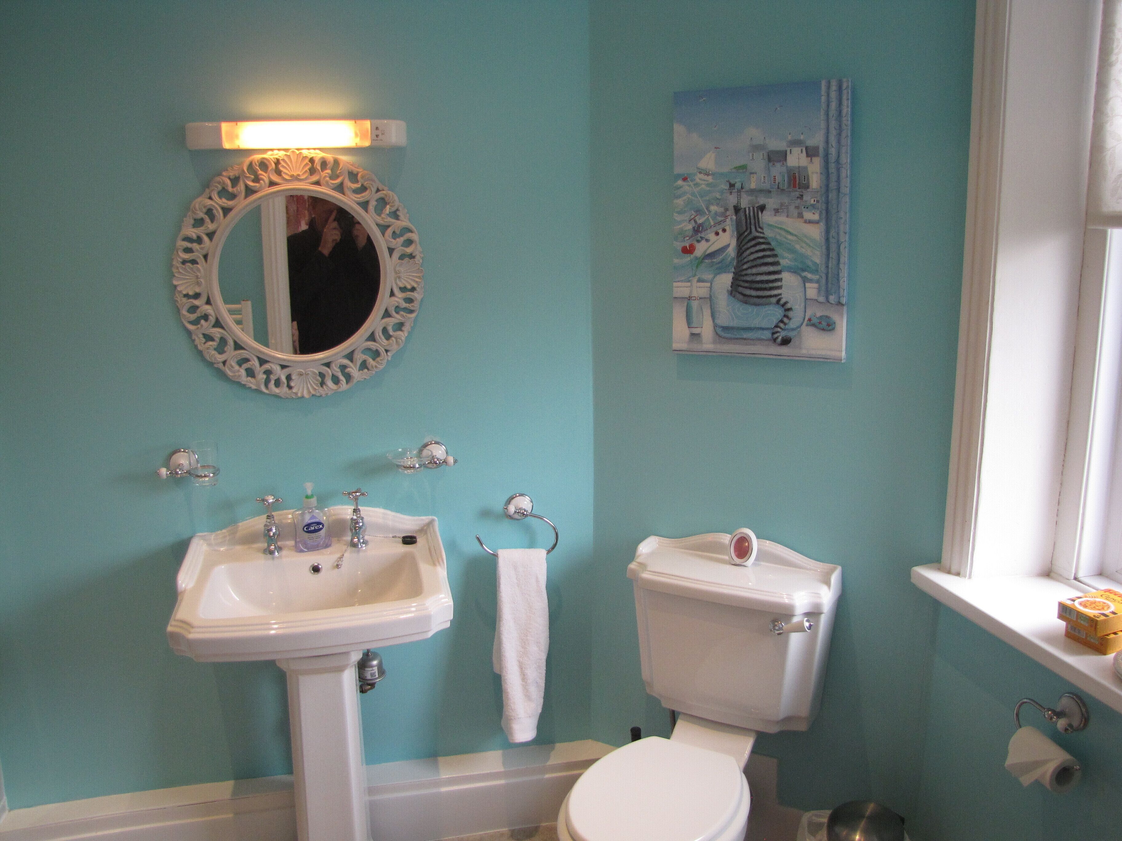 A bathroom with a sink, toilet, and a mirror.