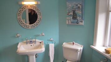 A bathroom with a sink, toilet, and a mirror.