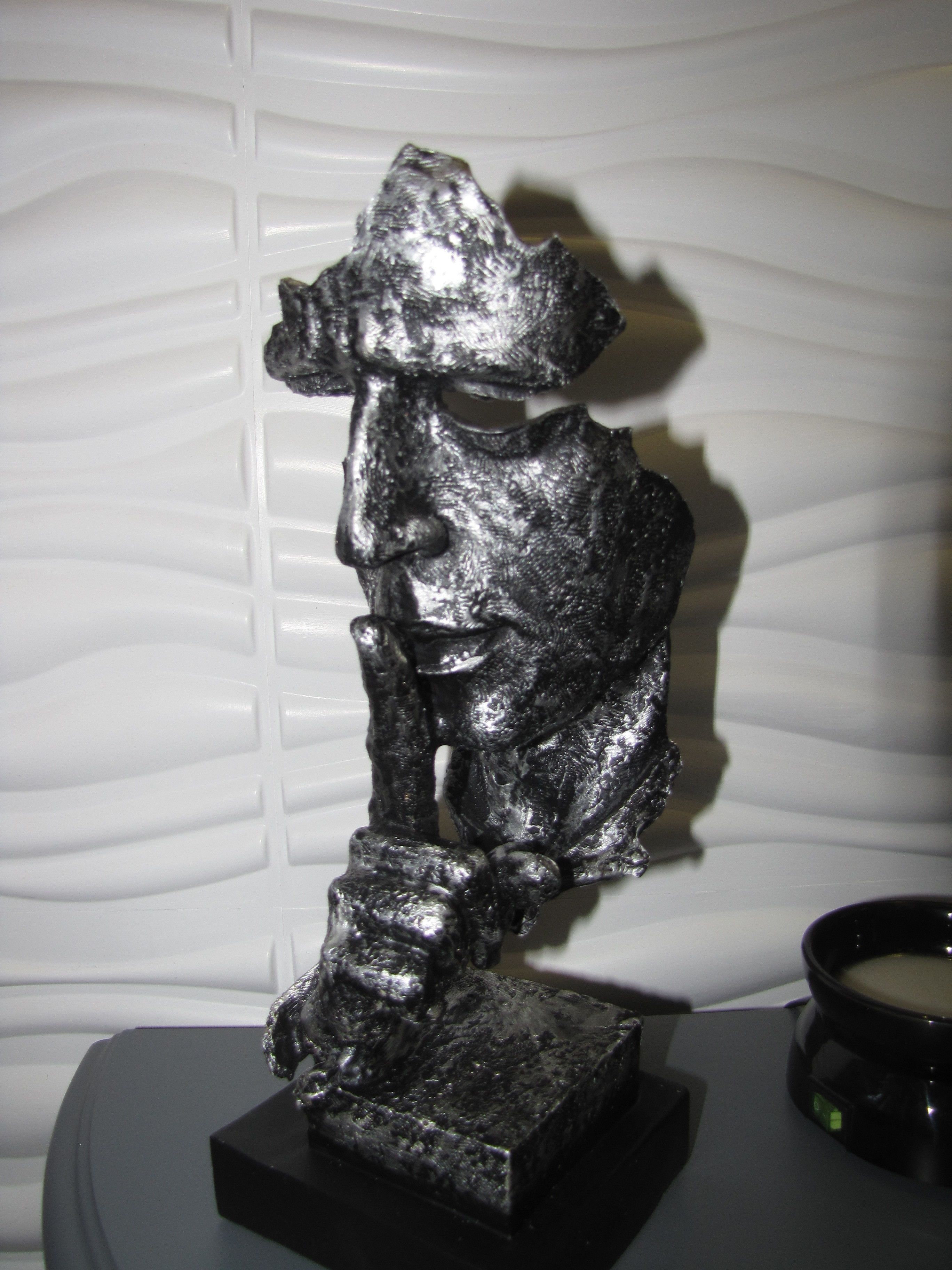 A sculpture of a human figure on a pedestal.