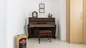 Un piano dans une pièce avec un meuble en bois et une canette de bière Guinness.