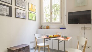 A dining area with a table, chairs, and a fruit bowl.