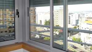 Una habitación con un amplio ventanal con vistas a la ciudad.